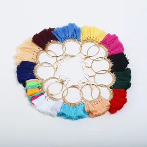 Detailansicht von bunten Quasten Creolen im lebendigen Boho Stil mit goldenen runden Ringen.