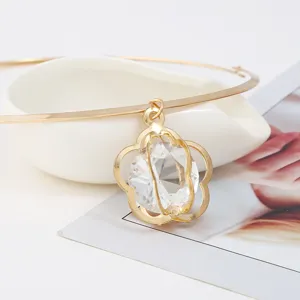 Nahaufnahme der goldenen Choker-Halskette mit Kristall-Anhänger, filigranes Hohlblumen-Design.