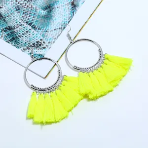 Nahaufnahme von leuchtend gelben Quasten Creolen, Boho Stil Modeschmuck Ohrringe Accessoire.