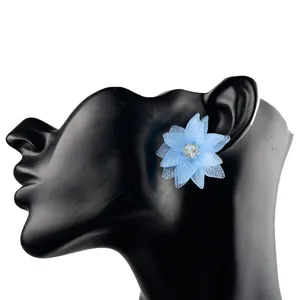 Detailansicht ohrringe acryl blume in blau mit funkelndem kristallstein im zentrum.