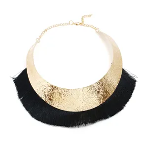 Detailansicht der goldenen Statement-Choker-Halskette, breiter Metallkragen mit Fransen.