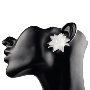 Nahaufnahme der weißen, mattierten Acryl-Blumenohrringe mit filigranen, feinen Blütenblättern.