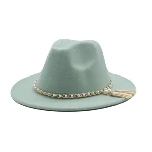 Nahaufnahme des mintgrünen Fedora-Hutes mit edler Perlenkette und stilvollen Quasten.
