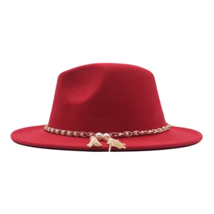 Roter Wolle Fedora Hut Detail mit Goldkette Perle Quaste Besatz eleganter Mode Winterartikel
