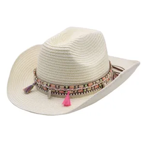 Chapeau de paille beige style western avec bande tressée, glands colorés et pendentifs coquillages.
