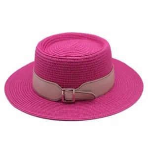 Detailed view of the stylish hot pink flat top straw hat featuring a chic light pink leather belt strap.