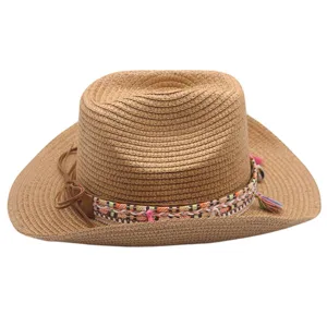 Vue rapprochée du chapeau de paille western avec bande tressée colorée et glands.