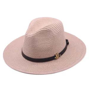 Eleganter rosa Strohhut mit schwarzem Lederband und goldenem M fur Strand und Sommer.