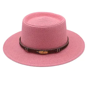 Rosa flacher Strohhut mit braunem Boho-Band und goldenem Feder-Anhänger für den Sommer.