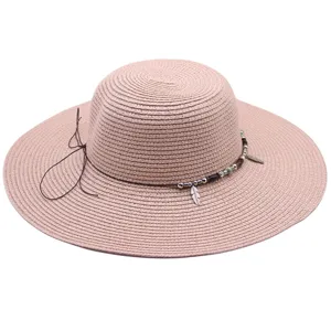 Detalle de primer plano del sombrero de paja para mujer con cuentas y abalorio de plumas.