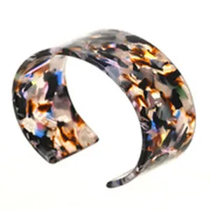 Bracciale polsino largo in resina tartaruga colorata, dettaglio bangle geometrico aperto chic.
