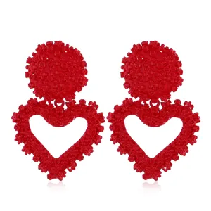 Orecchini a cuore con rilievo floreale rosso dettaglio primo piano gioiello moda!