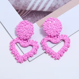 Chic orecchini a cuore in metallo floreale rosa, elegante design geometrico in rilievo.