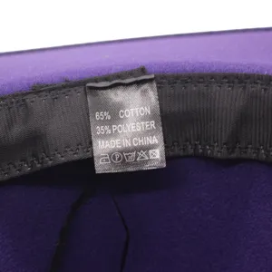 Nahaufnahme des inneren Waschetiketts des Hutes mit Angabe der Materialzusammensetzung.