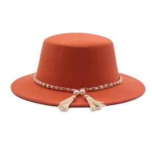 Oranger flacher Filzhut Detail mit eleganter Perlenkette und süssen Quasten Anhängern.