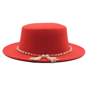 Roter flacher Filzhut im Detail zeigt elegante Perlenkette mit feinen Quasten Akzenten.