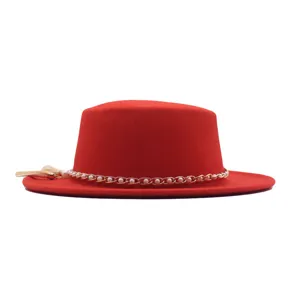 Roter Flachhut Detail aus Wolle mit eleganter Perlenkette und Quasten Zubehoer Nahaufnahme.