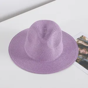 Nahaufnahme des eleganten lila geflochtenen Strohhutes, zeigt feine Textur und breite Krempe.