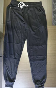 Vue détaillée du pantalon de jogging noir pour homme avec cordon réglable et poche zippée.