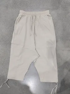 Detailed view of casual linen harem pants featuring elastic drawstring waist and adjustable cuffs.