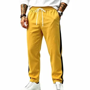 Men's yellow casual sweatpants side stripe detail close-up view showing adjustable drawstring.