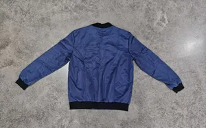 Back view detail of blue suede bomber jacket, casual MA1 style with black ribbed hem.