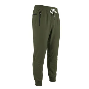 Vista di dettaglio dei pantaloni casual da uomo con tessuto verde, coulisse bianca e tasche zip.