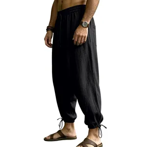 Detail view of black linen casual harem pants for men, featuring elastic drawstring waist.