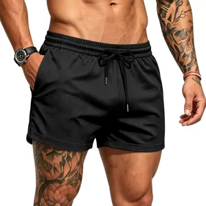 Detail shot of men's black athletic mesh shorts with elastic drawstring waist and pockets.
