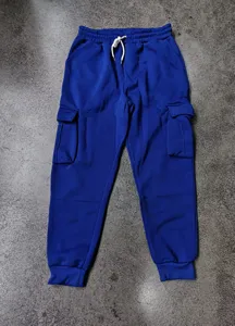 Vista dettagliata dei pantaloni cargo blu royal con coulisse bianca e tasche laterali.