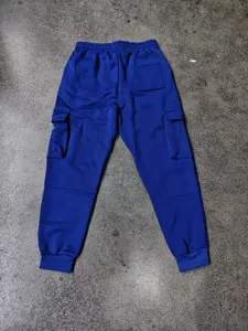 Dettaglio pantaloni tuta cargo blu, vita elastica, fondo risvolto, tasche multiple.