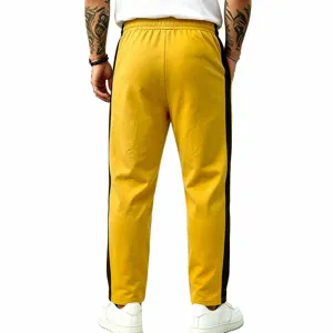 Back detail of men yellow sweatpants with black side stripes, showing relaxed fit and waist.