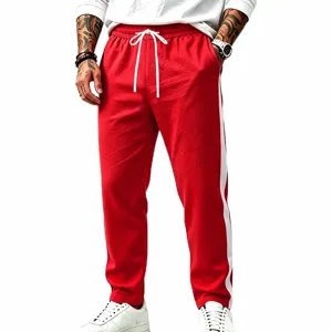 Detailed view of casual red sweatpants with white side stripes and adjustable drawstring waist.