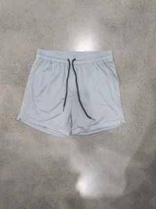 Grey quick-dry athletic shorts detail, lightweight mesh fabric with elastic waist and drawstring.