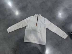 Detailed close-up shot of the white half-zip fleece sweatshirt collar and metal zipper.