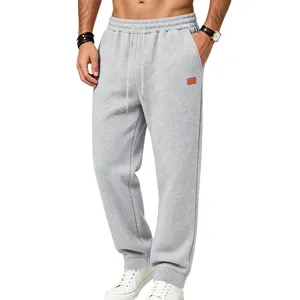 Detailed view of men's casual textured sweatpants, loose fit grey joggers with drawstring.