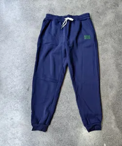 Detailed view of dark blue fleece-lined sweatpants, elastic drawcord waist, ribbed cuffs.