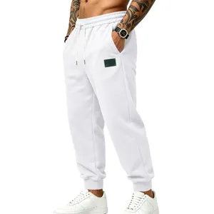 Close-up of white fleece jogger pants with drawstring waist and stitched logo patch.
