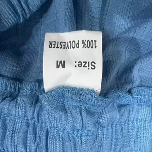 Close-up detail of men's casual knit shorts fabric and size label showing polyester material.