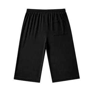 Men's black casual cropped shorts featuring an elastic waist and textured slub fabric.