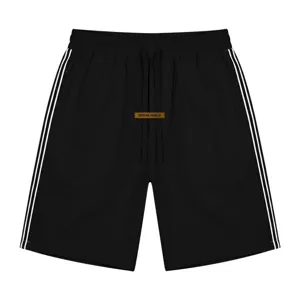 Vue rapprochée de short de sport noir avec bandes latérales blanches et cordon de serrage.