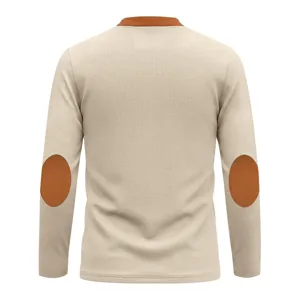 Detail view of a retro waffle knit long sleeve henley shirt with contrast elbow patches.