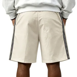 Shorts de sport décontractés pour hommes, tissu beige avec rayures latérales noires classiques.
