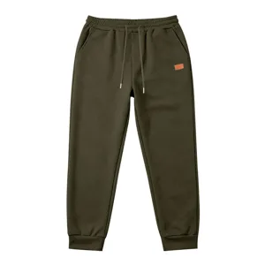 Men dark green textured sweatpants, loose fit, drawstring waist, waffle knit fabric.
