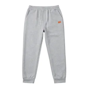 Detailed view of men's grey textured sweatpants, featuring adjustable drawstring and cuffed hem.