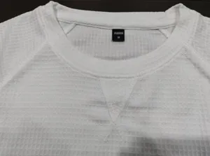 Weißes Waffelstrick Kurzarm T-Shirt Kragendetail mit Raglan-Design und V-förmiger Naht.