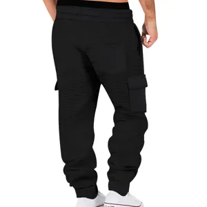 Vista trasera detalle pantalón cargo hombre negro de tejido gofrado con bolsillos y cordón.