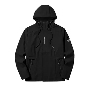Detailed close-up of black hooded windbreaker jacket featuring zipper pockets and sleeve badge.