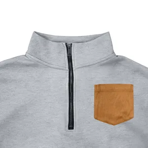 Men's fleece quarter-zip sweatshirt detail, grey pullover with brown chest pocket and mock neck.