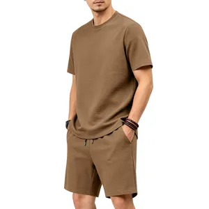 Close up view of mens brown textured short sleeve top and shorts set showing fabric detail.